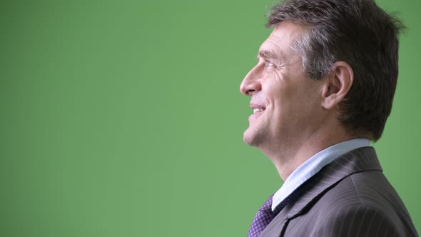 Mature Handsome Businessman Against Green Background