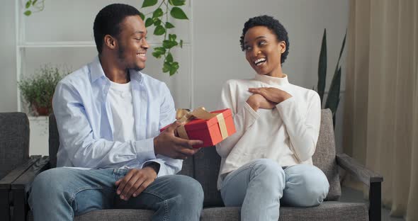 Beautiful Young Afro American Couple Sitting on Couch at Home