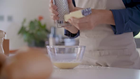 Detail of Man Hand Grating Parmesan Cheese with Grater