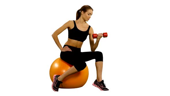 Girl Sitting on Pilates Ball and Exercising with Dumbbells. White Background