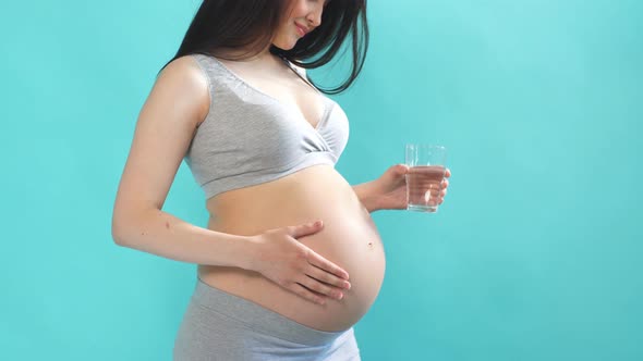 Young Pregnant Woman Drinking Refreshing Water From a Glass