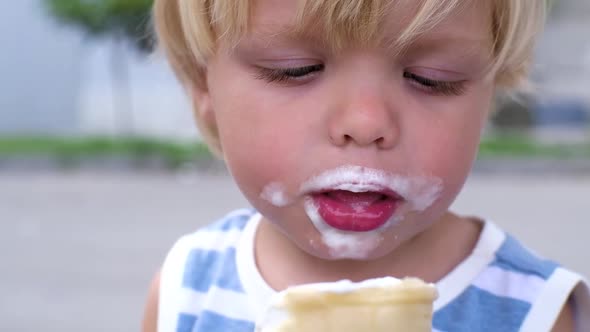 a Small Child Eats White Ice Cream with Great Pleasure Ice Cream on Face