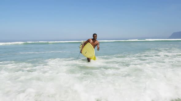 Male surfer walking with surfboard at beach 4k