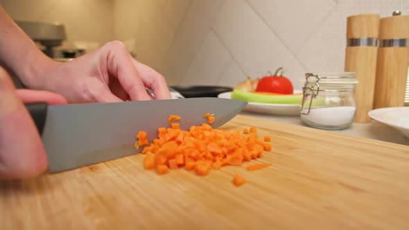 Woman Chopping Carrot in Kitchen Close Up