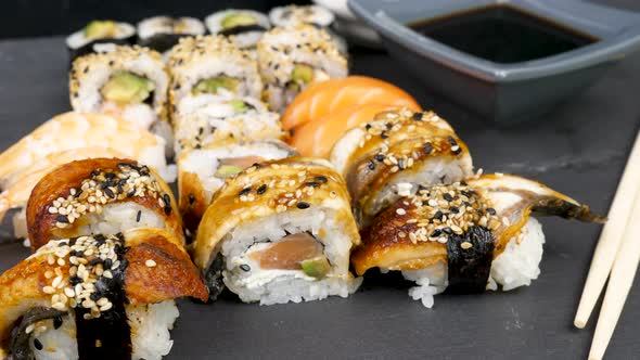 Different Sushi Rolls on Black Stone Plate