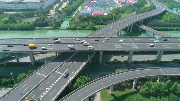 Aerial Orbital View of a Highway Overpass Multilevel Junction with Fast Moving Cars Surrounded By