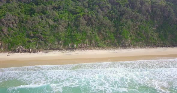 Spectacular aerial flight away from cliffs and trees over wild ocean, Australia