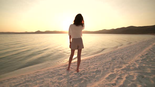 Female Model Walking on the White Sandy Beach of the Clear Tropical Turquoise Sea at Sunset
