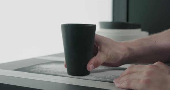 Slow Motion Man Hands Sand Bottom of Black Ceramic Glass