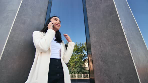 Smiling Trendy Girl Talking Use Smartphone at Modern Building Background