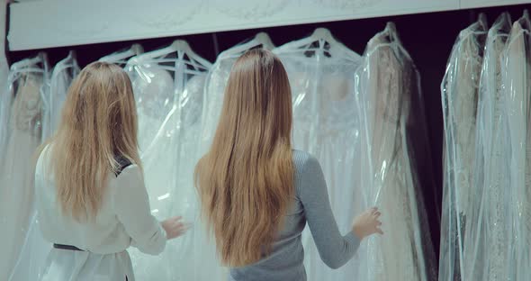 Girls Look at Wedding Dresses in the Salon