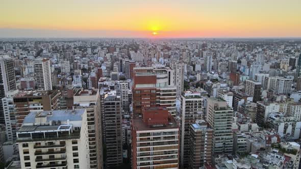 Dolly in flying over Belgrano neighborhood tall buildings at sunset, Buenos Aires, Argentina