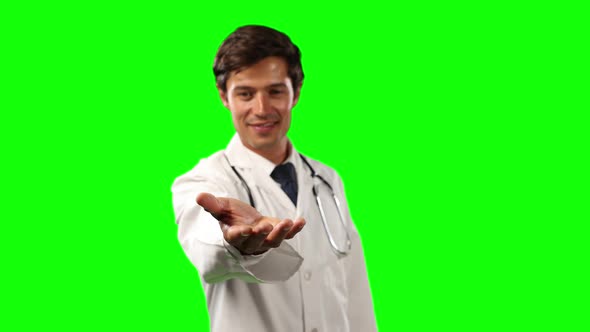 Front view of a doctor holding his hand for a copy space with green screen