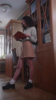 Education Stock Footage 4 K Ultra Hd Clips   A Woman Reading A Book While Leaning On A Bookshelf