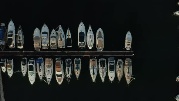 Birds Eye View of Sailboats in Harbour with Black Water Background, Aerial Top Down View