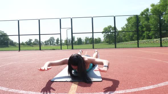 Fitness Woman in Sportswear Doing Various Exercises on Sports Mat, on an Orange Basketball Field