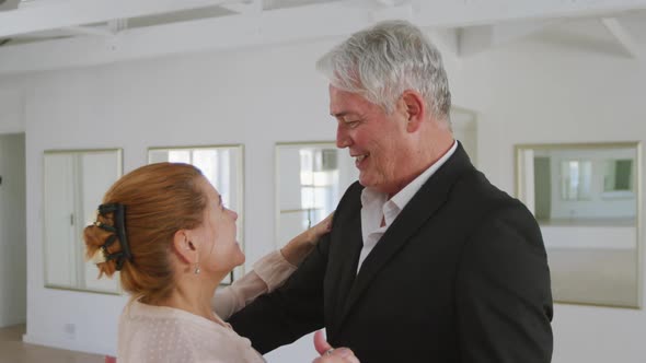 Caucasian senior couple spending time together dancing in a ballroom