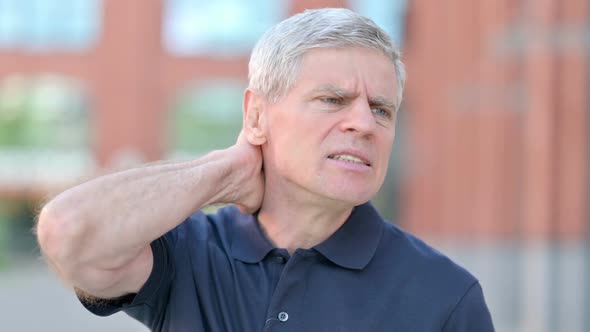 Outdoor Portrait of Tired Middle Aged Man Having Neck Pain