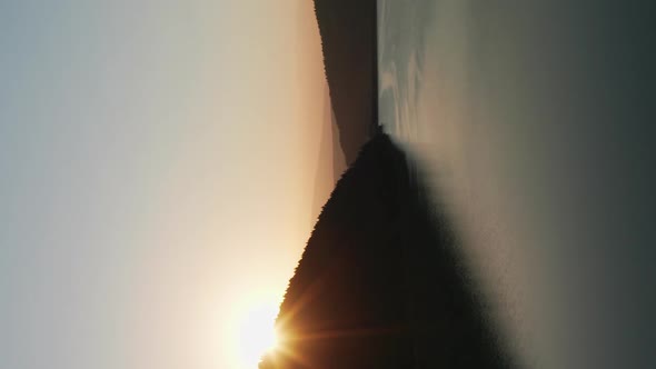 Vertical View Of Beautiful Frumoasa Dam In Harghita County, Romania With Sun Rising Behind Silhouett