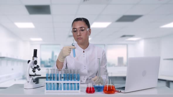 Woman Microbiologist Analyzes the Fluid in a Test Tube A Female Scientist Conducts Medical Research alt