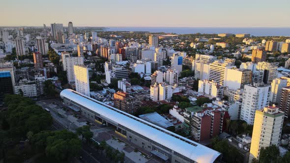 Orbital flying over Belgrano neighborhood train station with Rio de la Plata river in background, Bu