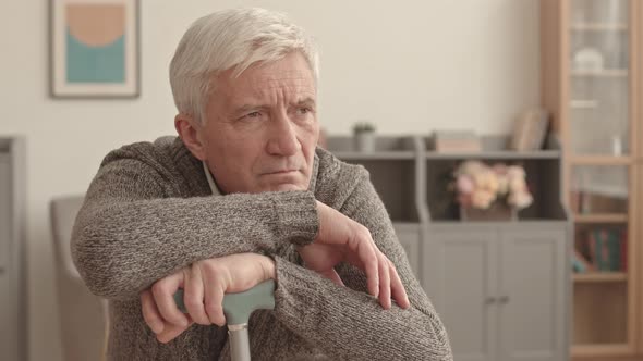 Depressed Man with Cane at Home