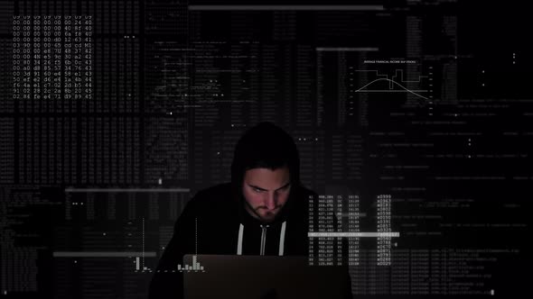 Black hooded hacker in midst of computer code is frantically typing on keyboard of his system and in