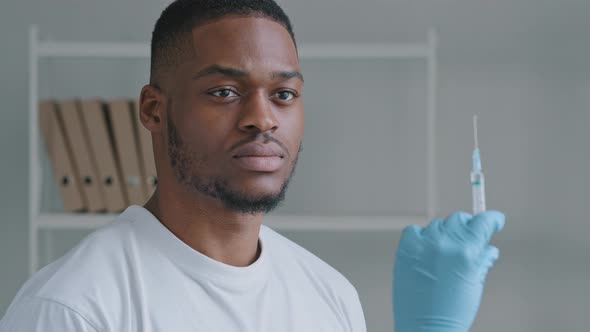 Afro American Man African Patient Guy Looking at Hands in Latex Gloves Holding Syringe with Medicine