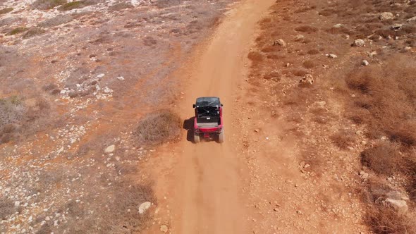Aerial tracking shot following ATV driving on the Cavo Greko dirt trails