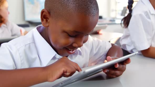 Schoolboy using digital tablet in classroom