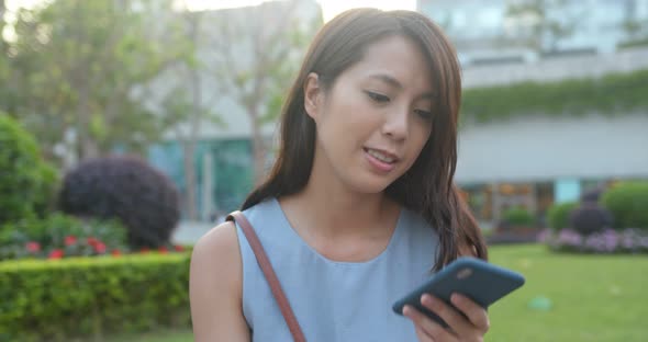 Woman look at the cellphone in park