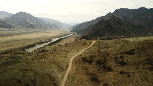 Two White Cars Drive Along a Mountain Road