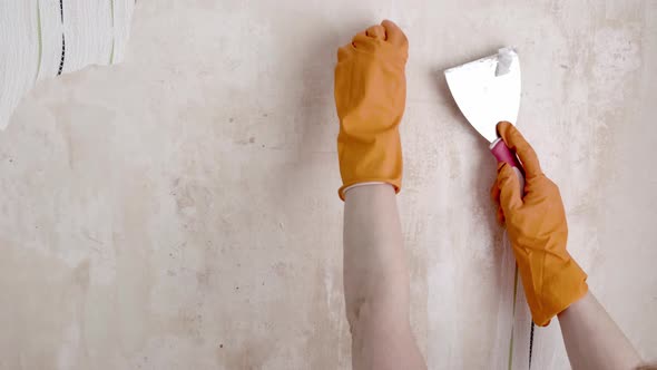 Woman Removing Old Wallpaper From Walls Preparing for Flat Renovation