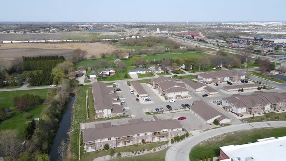 Aerial view at edge of community with mix of residential, farm, businesses, and transportation.