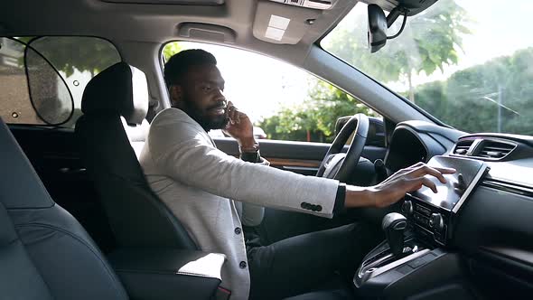 African American Businessman Sitting in the Driver's Seat ,Talking on Phone