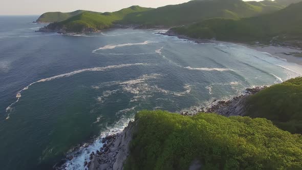 Drone View of the Sea Coast with Blue Water and Hills at Sunset