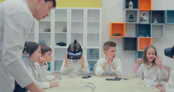 Little Boy and Little Girl in Virtual Reality Headset Standing in Classroom and Looking