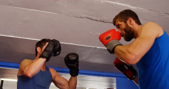 Man practising boxing with trainer