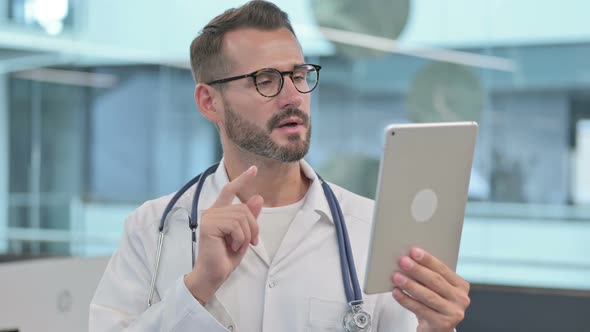 Middle Aged Male Doctor Doing Video Call on Tablet