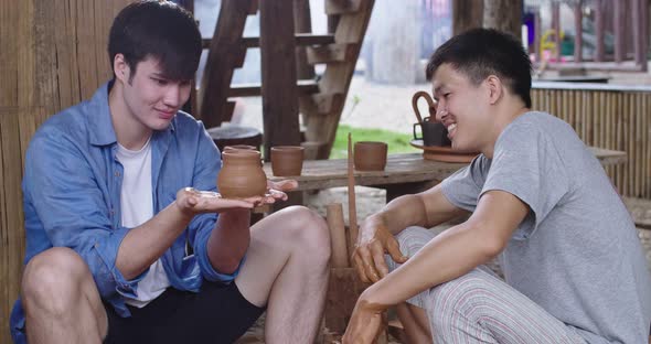 Male Pottery Maker Looking At Product