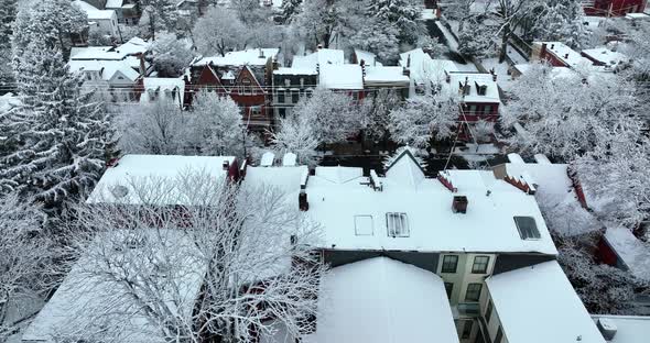 Winter aerial scene. Homes in urban city. Trees and rooftops covered with fresh snow.