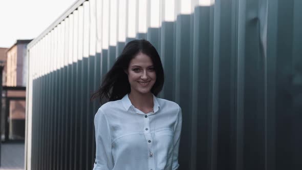 Attractive Girl of European Appearance Walks Down the Street Smiling