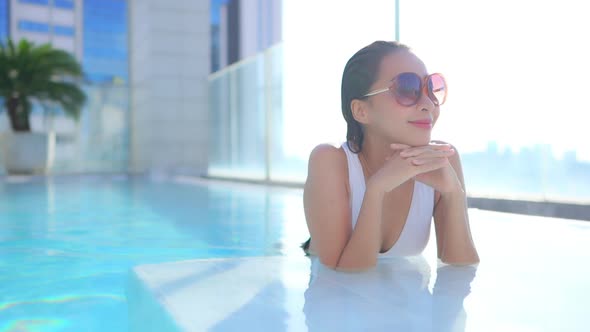 Young asian woman enjoy around outdoor swimming pool for leisure