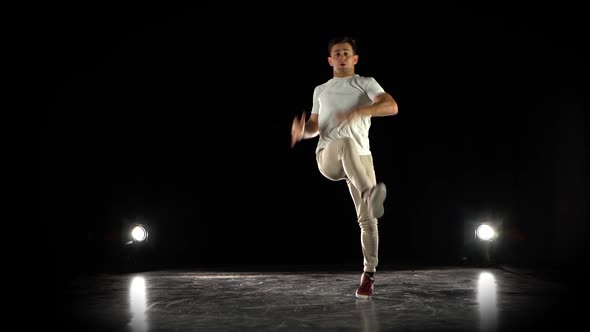 Young Man Dancing Breakdance in Black Studio