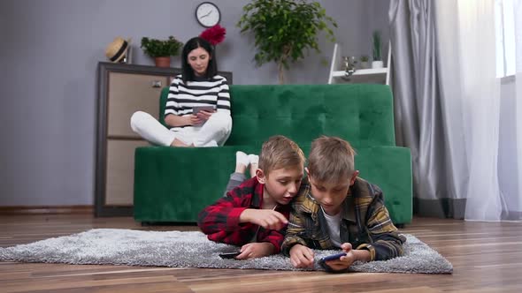 Mother and Her Two Sons which Spending Their Leisure at Watching Interesting Apps on Phones