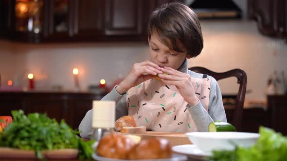 Brunette Caucasian Little Boy Enjoying Sandwich at Home