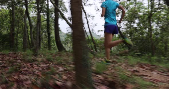 Woman runner running on forest trail, slow motion