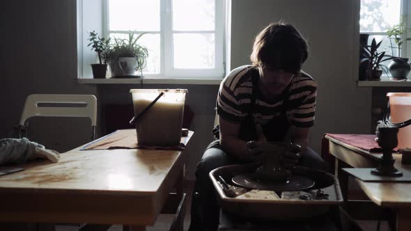 A Young Man Works in a Pottery Workshop