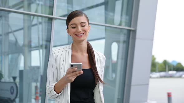 Beautiful Woman With Phone Walking Near Business Office