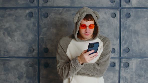 Man in Kigurumi and Sunglasses Using Smartphone